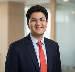 Professional portrait of Ishan Jain in a navy suit and red tie